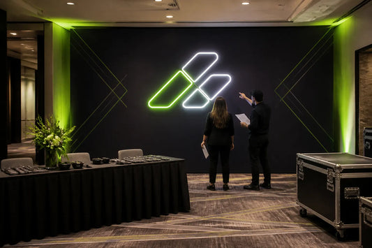 Corporate event planners reviewing an illuminated brand sign in a Canadian venue