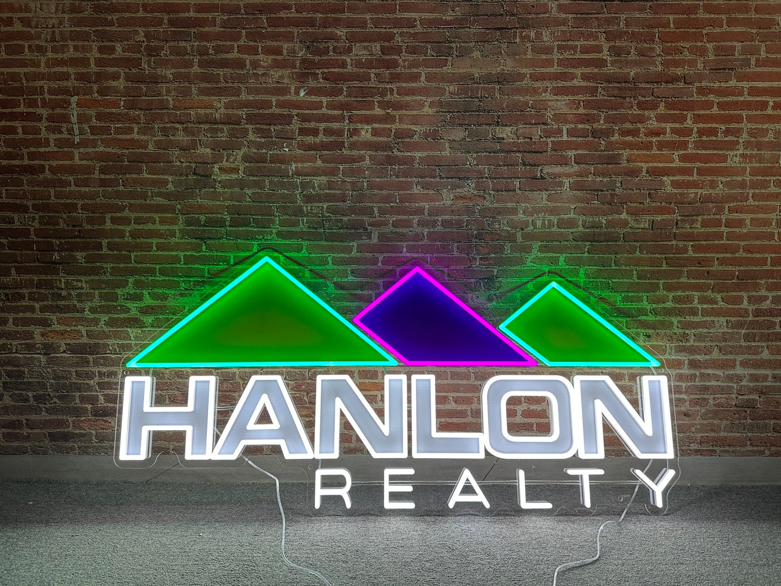 Hanlon Realty custom LED neon logo sign lit in green, purple and white